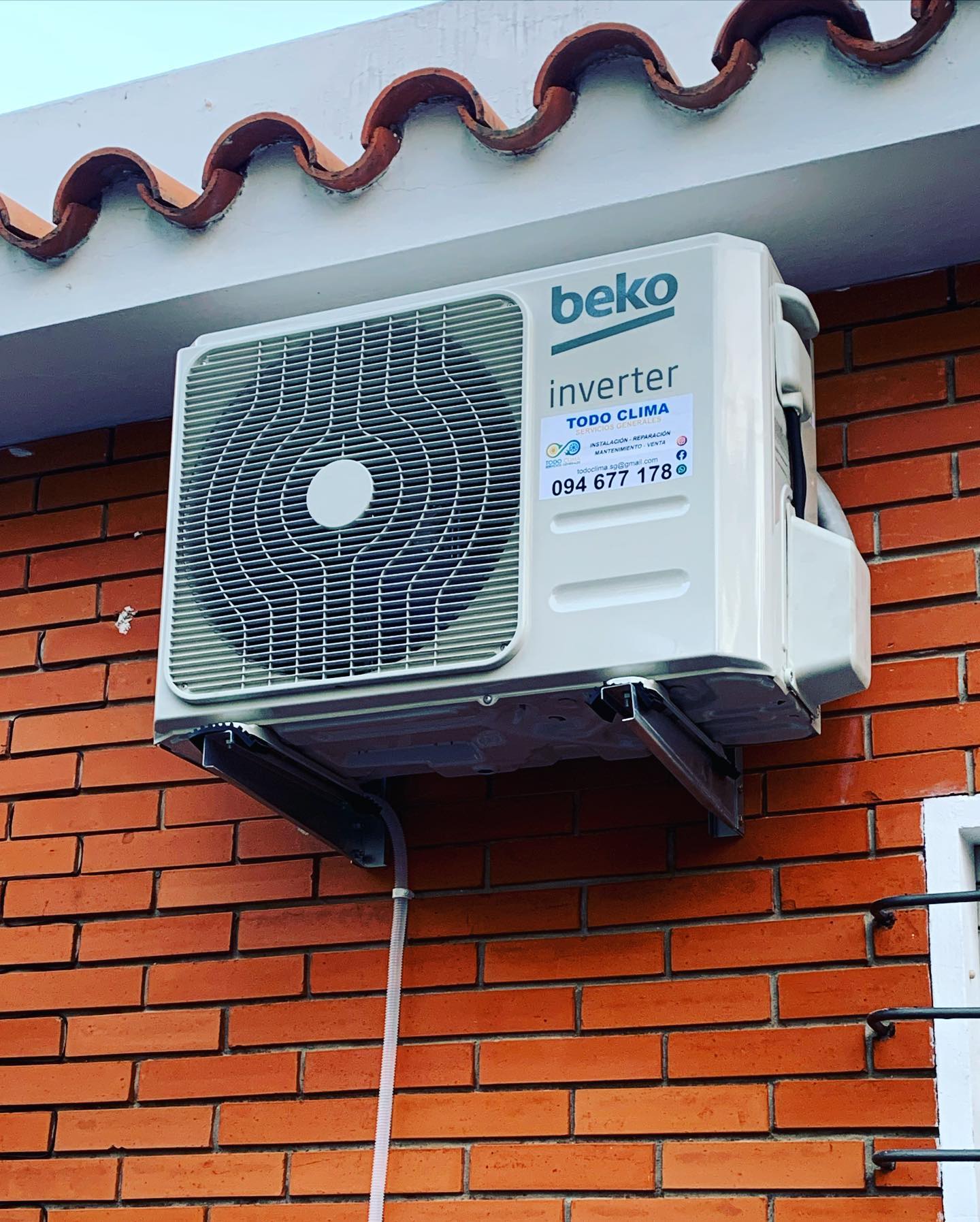 Unidad exterior Beko inverter instalada sobre ménsula en una pared de ladrillo